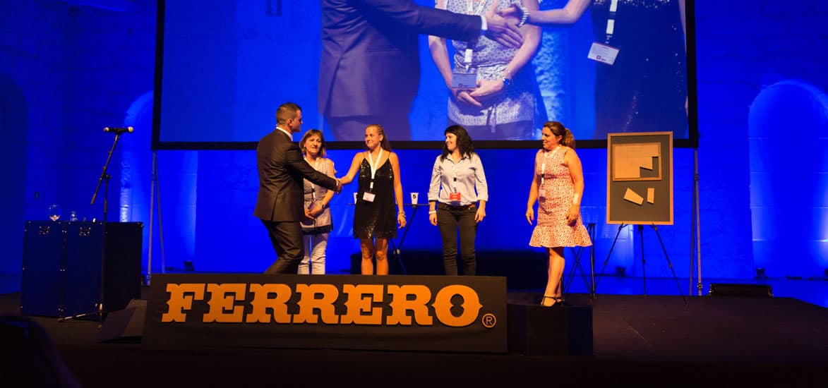 Nuno Rodrigues num espetáculo corporativo com a marca do cliente em palco
