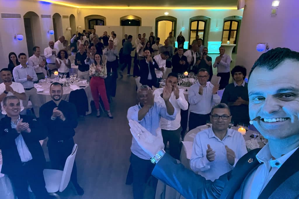 Sala de jantar com mesas redondas e convidados de pé a aplaudir o Nuno Rodrigues